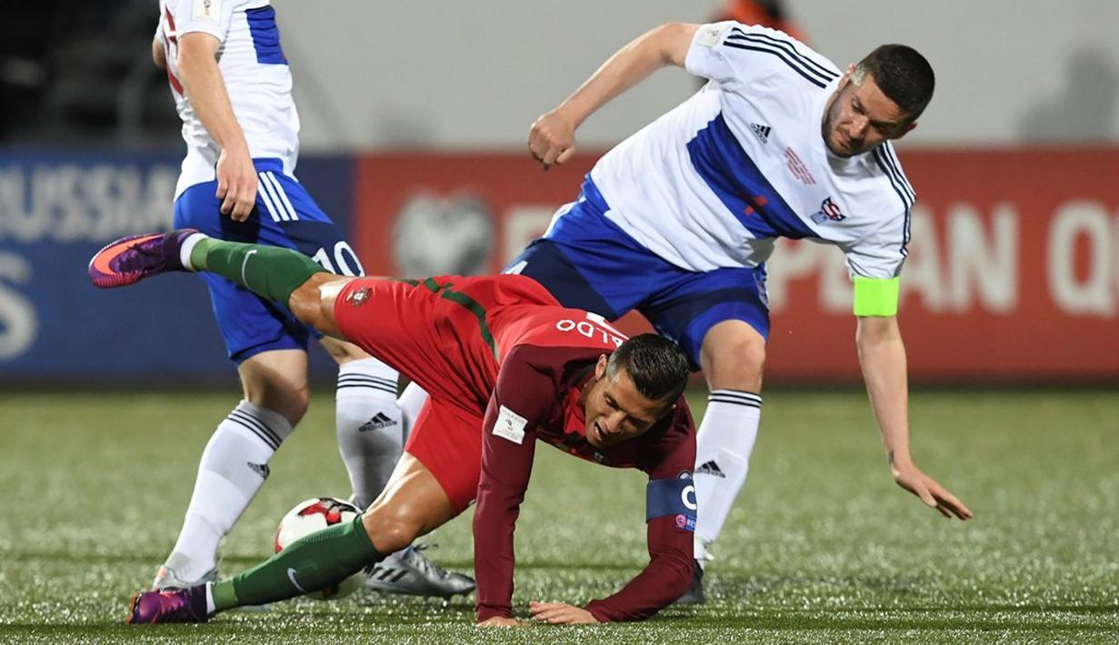 Cristiano Ronaldo dilanggar pemain Kepulauan Faroe pada laga Grup B Kualifikasi Piala Dunia 2018 zona Eropa di Torsvollur Stadium, Selasa (11/10/2016) dini hari WIB. (AFP/Francisco Leong)