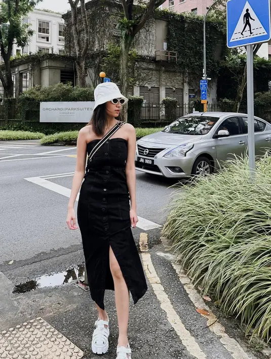 Playing tourist ala Azizah Salsha dengan strapless denim dress berwarna hitam. Dress ini memiliki detail manis high slit di bagian depan, ditambah bucket hat putih, dan sunglasses yang menyempurnakan penampilan Azizah. [Foto: Instagram/azizahsalsha_]