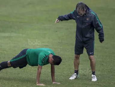 Gelandang Timnas Indonesia, Evan Dimas, diminta pelatih fisik, Miguel Gandia, untuk push up usai latihan di Stadion UKM, Selangor, Sabtu (19/8/2017). Evan kalah saat bermain crossbar dengan Miguel. (Bola.com/Vitalis Yogi Trisna)