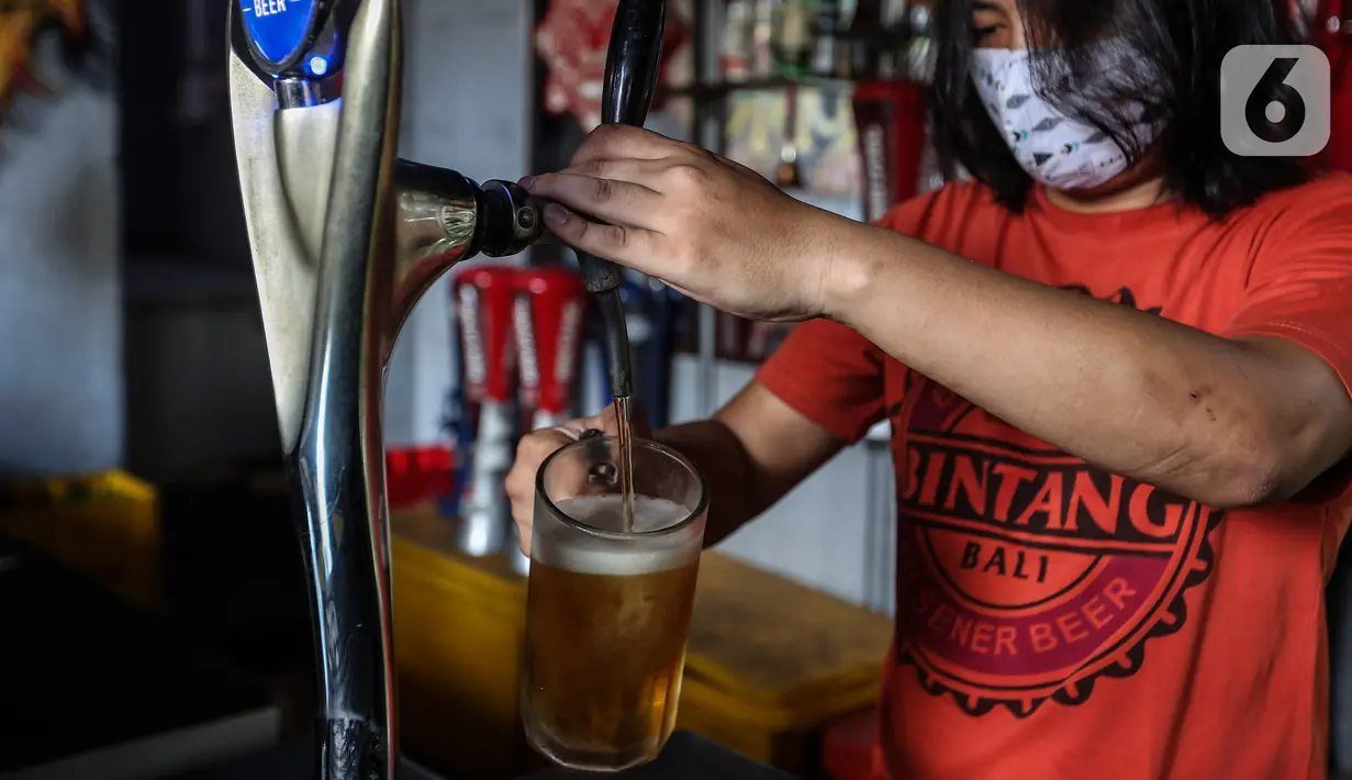 Pekerja menyiapkan minuman keras atau miras di mesin pendingin di salah satu kafe kawasan Jakarta Selatan, Selasa (2/3/2021). Aturan yang diteken oleh Presiden Joko Widodo pada 2 Februari 2021 terkait memperbolehkan masyarakat untuk berinvestasi di produk miras dicabut. (Liputan6.com/Johan Tallo)
