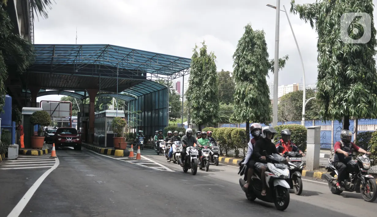 Pengendara motor melintasi Gerbang Tol Pulomas saat dialihkan akibat banjir di kawasan Cempaka Putih, Jakarta, Minggu (23/2/2020). Banjir yang melanda kawasan tersebut melumpuhkan akses di Jalan Ahmad Yani sehingga Gerbang Tol Pulomas dibuka untuk pengendara motor. (merdeka.com/Iqbal S. Nugroho)