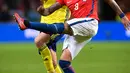 Gelandang Chile, Arturo Vidal berusaha membuang bola dari kawalan gelandang Swedia, Sebastian Larsson saat bertanding pada pertandingan persahabatan internasional Friends di Arena, Stockholm, (24/3). Chile menang 2-1. (Anders Wiklund/TT via AP)