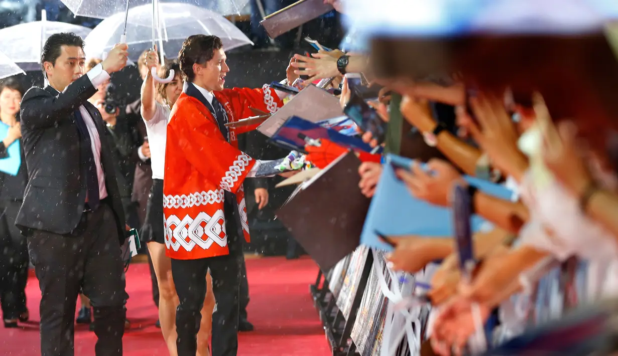 Tom Holland menyapa penggemar yang hadir di pemutaran perdana film “Spider-Man: Homecoming” di Tokyo, Senin (7/8). Pemeran Peter Parker ini datang mengenakan baju tradisional Jepang ‘Happi’ atau lebih dikenal dengan kimono. (Shizuo Kambayashi /AP)