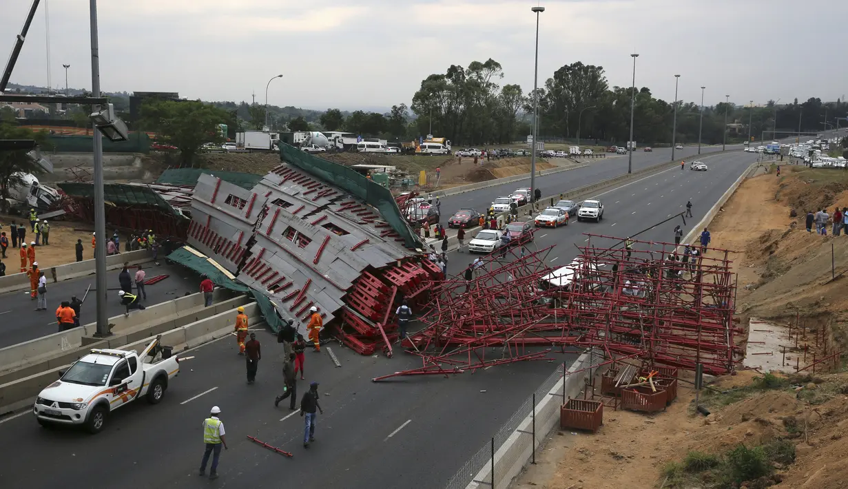 Warga mengamati perancah atau scaffolding sebuah jembatan yang sedang dibangun ambruk di jalan tol M1 menuju Sandton, Afrika Selatan, Rabu (14/10). Kejadian itu menewaskan dua orang dan20 lainnya cedera, menurut kantor SAR lokal. (REUTERS/Siphiwe Sibeko)