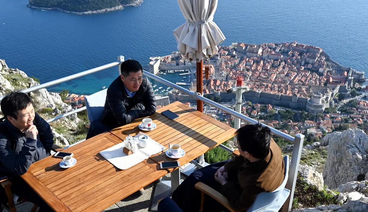 Wisatawan menikmati kopi dari puncak Bukit Srd menghadap ke kota tua Dubrovnik pada 28 Maret 2019. Tahun lalu lebih dari 1,2 juta turis mengunjungi Dubrovnik, kota yang paling banyak dikunjungi di Kroasia. (Denis LOVROVIC / AFP)