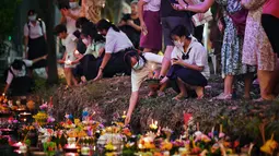 Orang-orang melepaskan lampion mengambang di kolam selama festival Loy Krathong di Bangkok (8/11/2022). Penghormatan tersebut dilakukan dengan cara melepaskan teratai yang dihiasi dengan lilin, dupa dan bunga ke air. (AFP/Lillian Suwanrumpha)