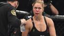 Ronda Rousey tampak lelah saat ronde pertama pada pertarungan perebutan gelar juara kelas bantam UFC Women melawan Holy Holm di Stadion Etihad, Melbourne, Minggu (15/11/2015). (AFP Photo/Paul Crock)