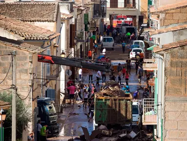 Sejumlah warga membersihkan rumah mereka yang terkena banjir bandang di Sant Llorenc, Mallorca, Spanyol (11/10). Banjir bandang tersebut telah menewaskan setidaknya 10 orang. (AP Photo/Francisco Ubilla)