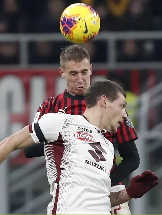 Bek AC Milan, Andrea Conti berebut bola udara dengan penyerang Torino, Andrea Belotti pada pertandingan perempat final Coppa Italia di stadion San Siro, Milan (28/1/2020). AC Milan menang 4-2 atas Torino dan melaju ke babak semifinal melawan Juventus. (AP Photo/Antonio Calanni)