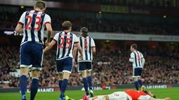 Striker Arsenal, Olivier Giroud, terjatuh setelah gagal memanfaatkan peluang di depan gawang West Bromwich Albion pada lanjutan Liga Inggris di Stadion Emirates, London, Jumat (22/4/2016) dini hari WIB. (AFP/Glyn Kirk)
