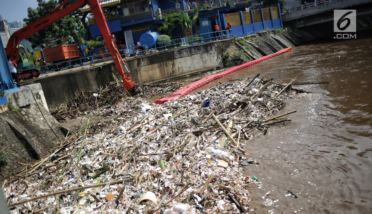Alat berat (becko) beroperasi mengangkut sampah yang menumpuk di Pintu Air Manggarai, Jakarta, Selasa (26/2). Meningkatnya debit air Sungai Ciliwung menyebabkan terjadi penumpukan sampah di Pintu Air Manggarai. (Liputan6.com/Faizal Fanani)
