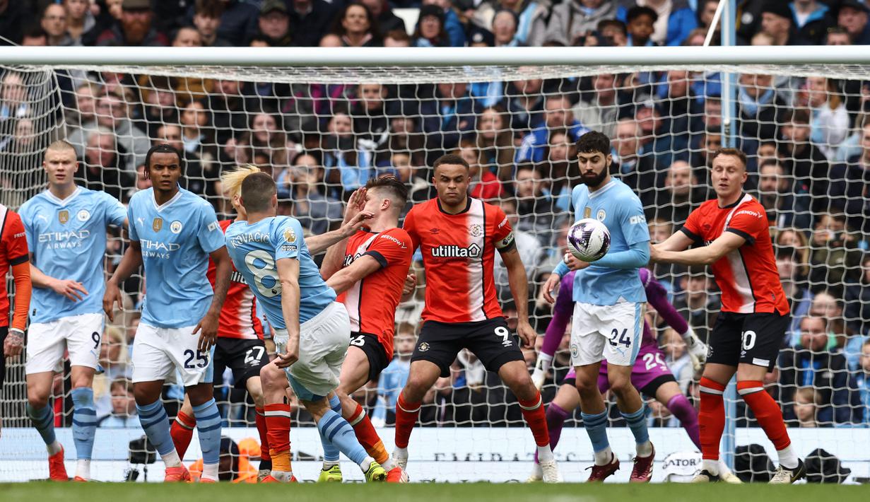 Gelandang Manchester City, Mateo Kovacic (tengah) mengeksekusi tendangan bebas yang berbuah gol kedua timnya ke gawang Luton Town pada laga pekan ke-33 Premier League 2023/2024 di Etihad Stadium, Manchester, Sabtu (13/4/2024). (AFP/Darren Staples)
