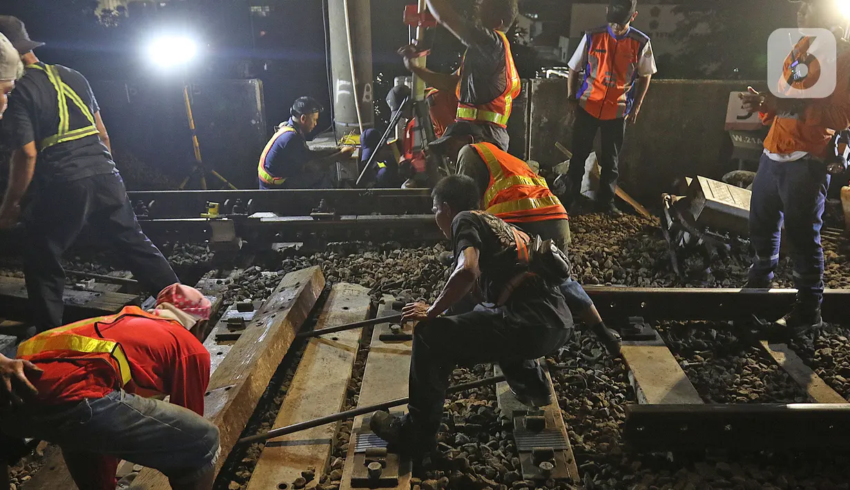 Sejumlah petugas merevitalisasi wesel rel di Stasiun KA Gambir, Jakarta, Kamis (14/2/2020) malam. PT KCI dan PT KAI Daop 1 Jakarta mengganti wesel rel di Stasiun Gambir dan Stasiun Jakarta Kota secara paralel yang akan berlangsung pada 13-23 Februari 2020. (Liputan6.com/Herman Zakharia)