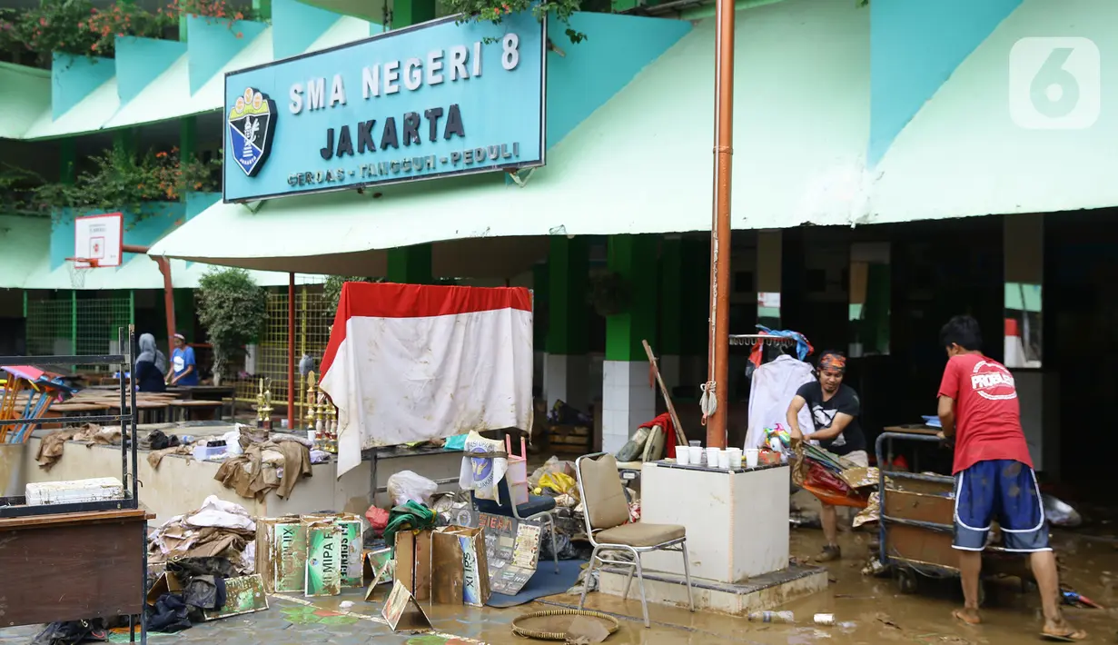 Guru dan murid SMA Negeri 8 Jakarta membersihkan sekolah pascabanjir di Bukit Duri, Tebet, Sabtu (4/1/2020). Data Kemendikbud menyebutkan per 3 Januari 2020 terdapat 201 sekolah terendam banjir dan 89 sekolah mengalami gangguan pada akses menuju sekolah. (Liputan6.com/Herman Zakharia)