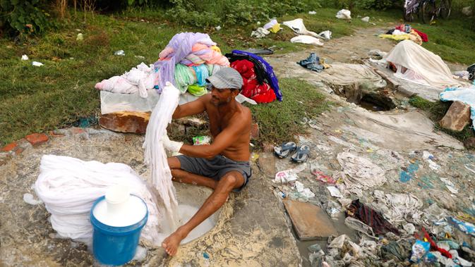 Dhobi, atau tukang cuci mencuci kain di tepi Sungai Gomti di Lucknow, 12 September 2020. Pekerjaan yang telah ada selama beberapa generasi  ini masih populer di India, meskipun ada teknologi modern dengan penghasilan setiap keluarga sekitar 100-200 dollar AS per bulan. (AP Photo/Rajesh Kumar Singh)