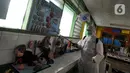 Petugas Palang Merah Indonesia (PMI) melakukan penyemprotan disinfektan di SMPN 216 Jakarta, Senin (16/3/2020). Mulai hari ini, aktivitas sekolah di sejumlah wilayah Indonesia diliburkan untuk mengantisipasi penyebaran virus corona COVID-19. (merdeka.com/Arie Basuki)