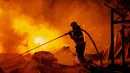 Petugas pemadam kebakaran memadamkan api setelah rudal Rusia menghantam sebuah gudang di Kyiv, Ukraina, Rabu, 5 Agustus 2026. (Foto AP/Dan Bashakov)