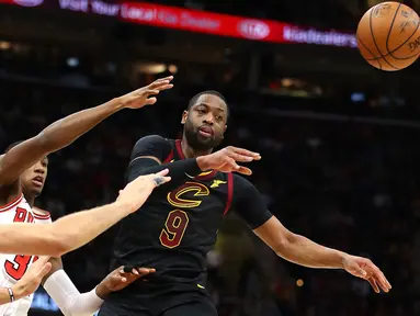 Pemain Cleveland Cavaliers, Dwyane Wade #9 memberikan umpan kepada rekannya saat diadang para pemain Chicago Bulls pada laga NBA basketball game di Quicken Loans Arena, Cleveland, (21/12/2017). Cleveland menang 115-112.  (Gregory Shamus/Getty Images/AFP)