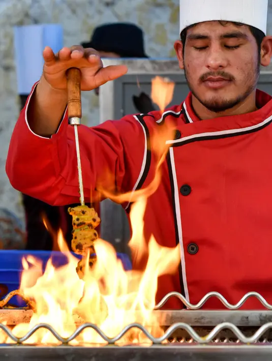 Seorang koki memanggang kebab sayuran di sebuah kedai makanan dalam festival Bengaluru Aaharotsava, Bangalore, India, Jumat (18/10/2019). Bengaluru Aaharotsava adalah festival makanan terbesar di Bangalore. (Manjunath Kiran/AFP)