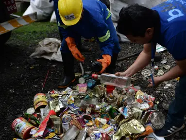 Pekerja perusahaan daur ulang mengamati sampah yang dikumpulkan dari Gunung Everest di Kathmandu, 5 Juni 2019.  Ekspedisi pembersihan Gunung Everest oleh pemerintah Nepal mengangkut turun 11 ton sampah sebagai bagian dari upaya membersihkan gunung tertinggi di dunia itu. (PRAKASH MATHEMA/AFP)