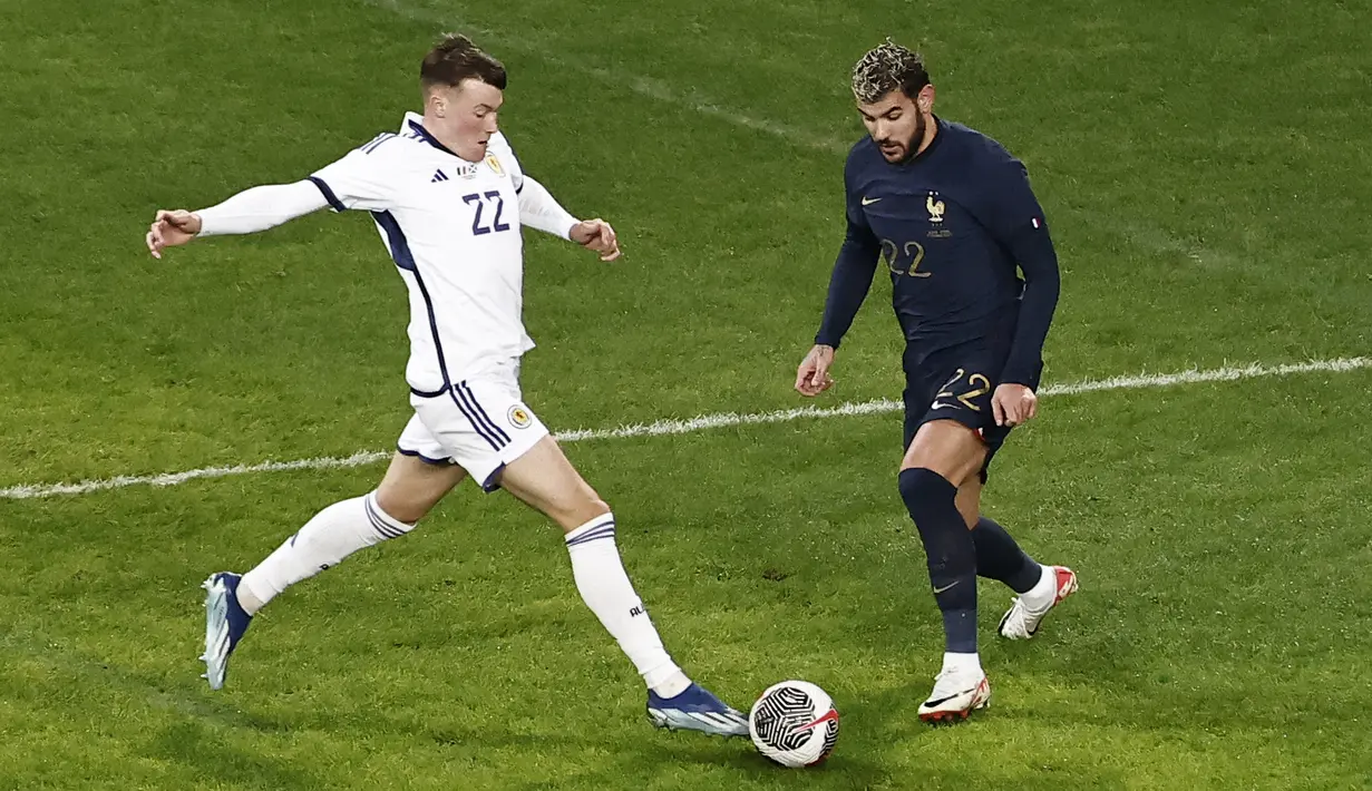 Penyerang Skotlandia #22 Nathan Patterson berebut bola dengan bek Prancis #22 Theo Hernandez pada laga persahabatan di Decathlon Arena, Rabu (18/10/2023) dini hari WIB. (Sameer Al-Doumy / AFP)