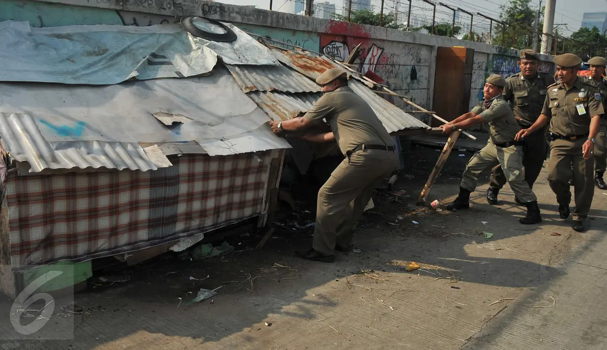 Petugas Satpol PP menertibkan sekitar 300 gubuk liar disepanjang Jalan Inspeksi Kanal Banjir Barat (KBB), Rabu (13/7). Penertiban dilakukan lantaran gubuk liar tersebut berdiri di bahu jalan dan mengganggu ketertiban umum. (Liputan6.com/Gempur M Surya)