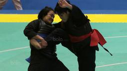 Aksi pesilat Laos, Olahthai Sounthavong beursaha membanting Octaviani Nirmalasari (kanan) pada semifinal Test Event Pencak Silat 2018 di Padepokan Silat TMII, Jakarta, (12/2/2018). Oktaviani menang 5-0. (Bola.com/Nick Hanoatubun)