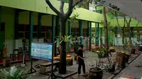 Pekerja membersihkan reruntuhan genting yang memenuhi halaman sekolah akibat gempa di SMK Negeri 1 Turen, Malang, Jawa Timur, Minggu (11/4/2021). Gempa yang mengguncang kawasan Malang dan sekitarnya membuat sejumlah bangunan rusak. (merdeka.com/Nanda F. Ibrahim)