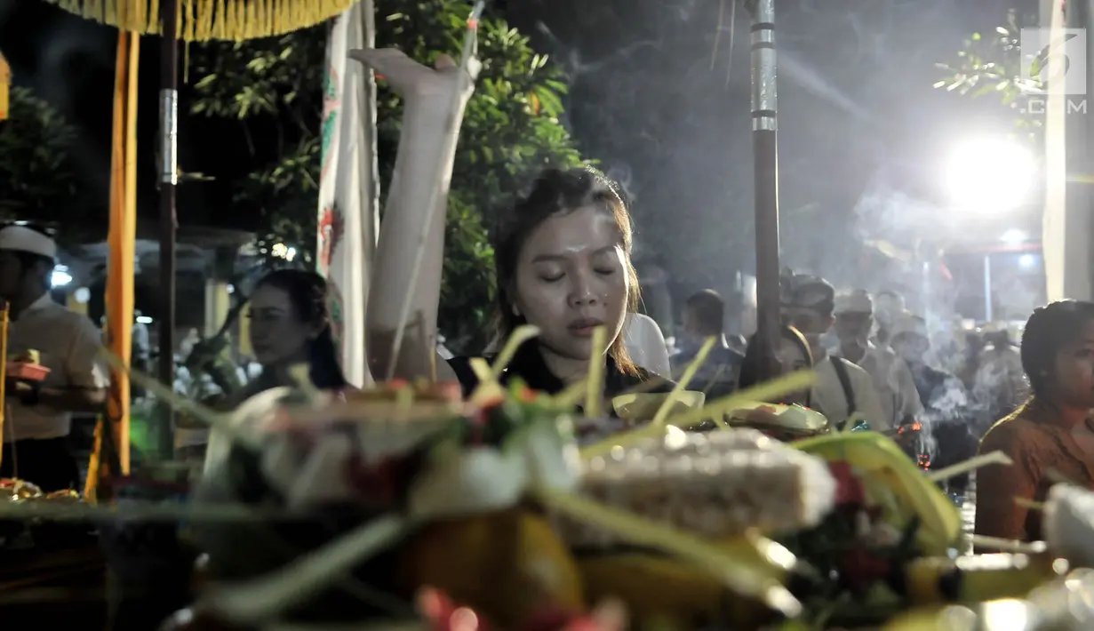 Umat Hindu berdoa saat sembahyang malam (Tilem Kesanga) menjelang Nyepi Tahun Baru Saka 1941 di Pura Aditya Jaya, Jakarta, Rabu (6/3). Sembahyang Tilem Kesanga merupakan salah satu rangkaian ibadah umat Hindu menjelang Nyepi. (merdeka.com/Iqbal S Nugroho)