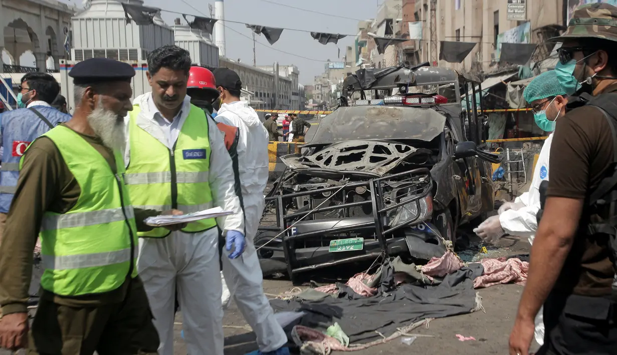 Petugas keamanan dan anggota tim penjinak bom mengamankan lokasi ledakan bom di luar tempat suci umat muslim Sufi, Lahore, Pakistan, Rabu (8/5/2019). Selama ini, pengikut aliran Sufi di Pakistan kerap menjadi target serangan mematikan oleh kelompok militan Islam, termasuk ISIS. (REUTERS/Mohsin Raza)