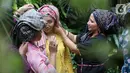 Perempuan belajar mengenakan penutup kepala Tengkuluk pada acara Ngopi Tengkuluk, Mengenal Penutup Kepala Perempuan Indonesia di Depok, Minggu (26/09/2021). Tengkuluk biasa disebut takuluk atau kuluk berkembang di lingkungan suku Melayu di Kota Jambi dan Pantai Timur Sumatra.(Liputan6.com/HO/Sybli)