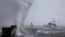 Sebuah perahu nelayan tiba di pelabuhan Plobannalec-Lesconil, Prancis Barat, pada 22 Oktober 2025, saat gelombang besar dan angin kencang menerjang pantai selama badai Benjamin melintas. (Fred TANNEAU/AFP)