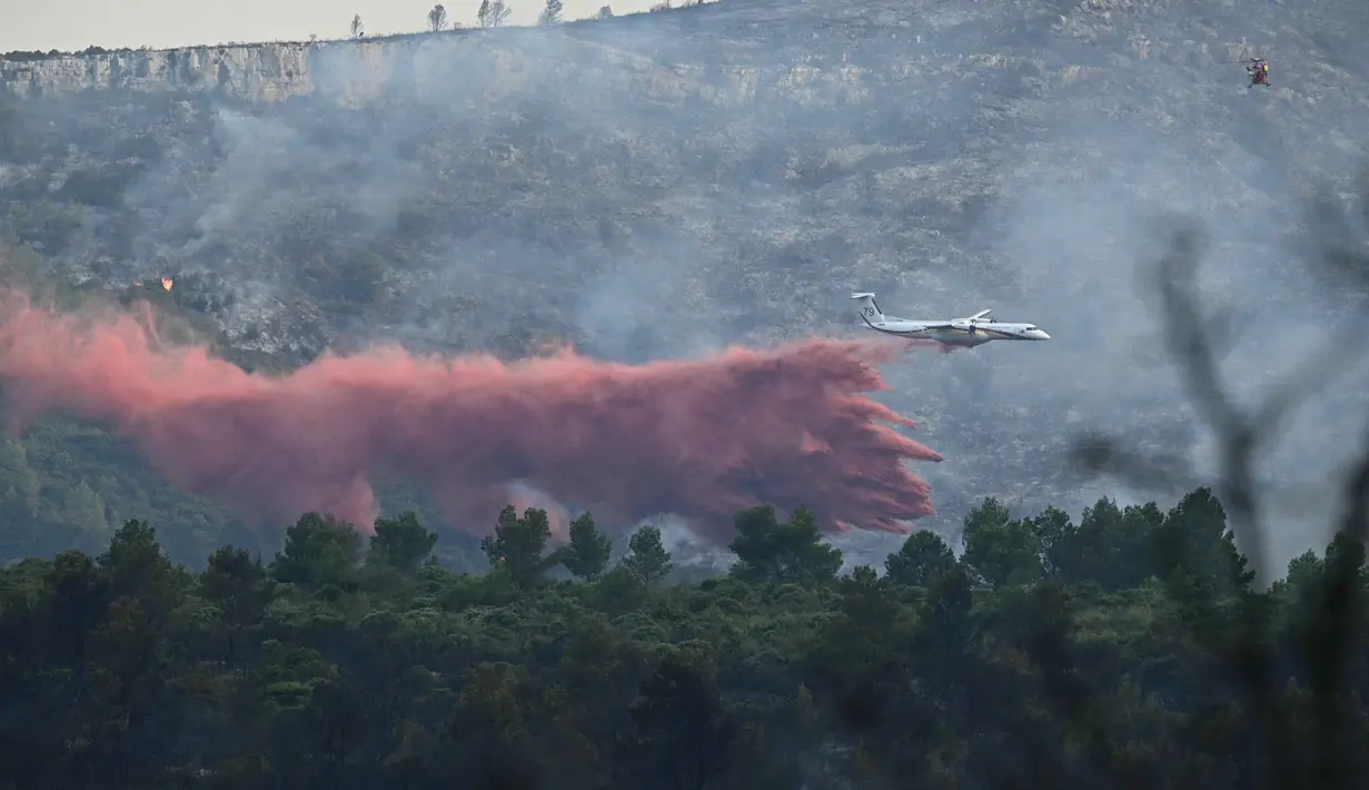 Sebuah pesawat Kanada milik keamanan sipil Prancis menjatuhkan cairan anti api di atas kebakaran hutan di dekat Fontjoncouse, Prancis barat daya, pada 6 Agustus 2025. (Lionel BONAVENTURE/AFP)