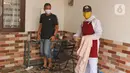 Tukang cukur mengenakan APD usai memotong rambut di halaman rumah pelanggan, Kelapa Dua, Depok, Jawa Barat, Senin (27/4/2020). Penerapan PSBB Kota Depok membuat tukang cukur tersebut menerima jasa panggilan ke rumah dan mengenakan APD untuk mencegah penularan COVID-19. (Liputan6.com/Herman Zakharia)