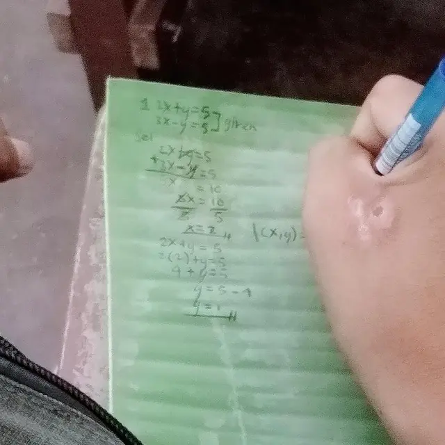 Erlande Monter sedang mencatat menggunakan daun pisang