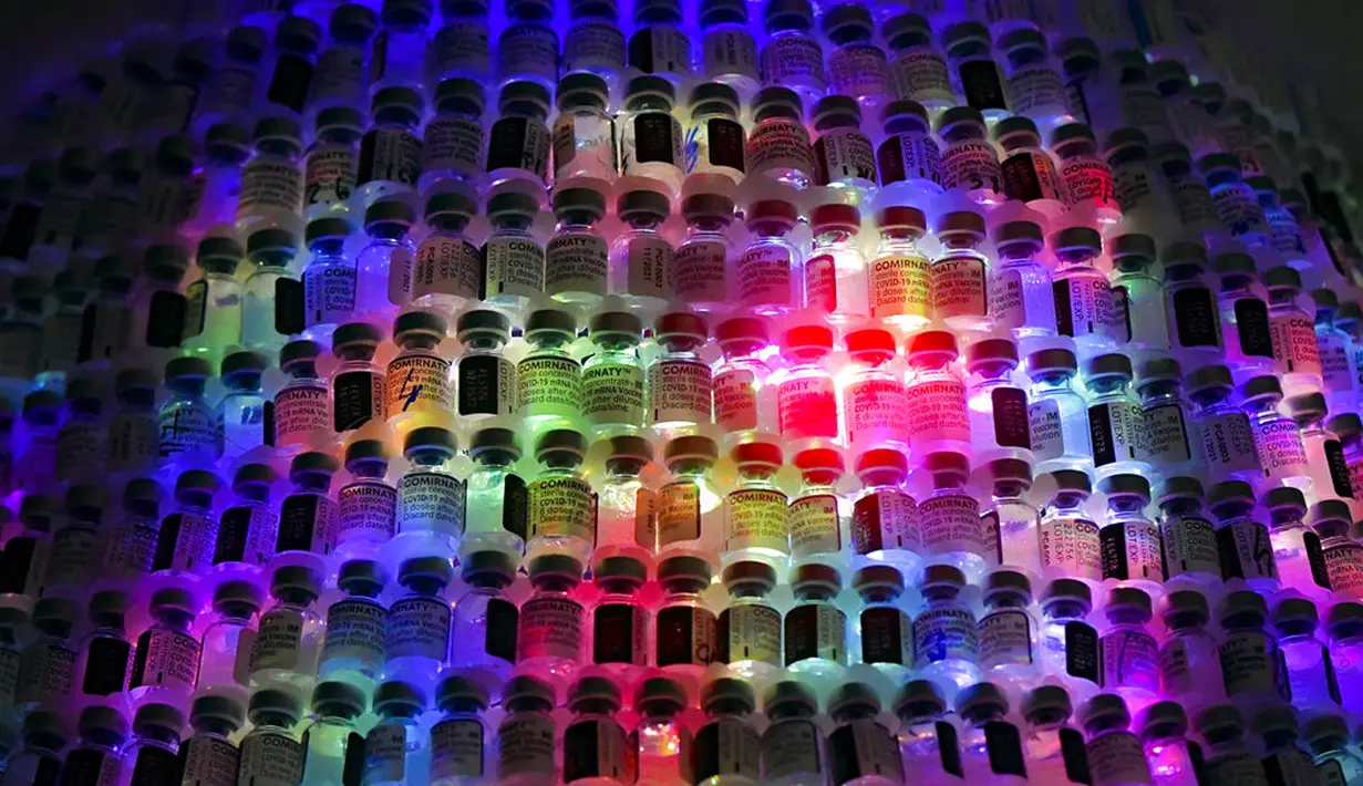 LED bersinar dalam pohon Natal yang terbuat dari botol vaksin kosong di pusat vaksinasi di Bucharest, Rumania, 6 Desember 2021. Salah satu pusat vaksinasi COVID-19 terbesar di Bucharest membangun pohon Natal setinggi tiga meter dari 19 ribu botol vaksin COVID-19 kosong. (AP Photo/Andreea Alexandru)