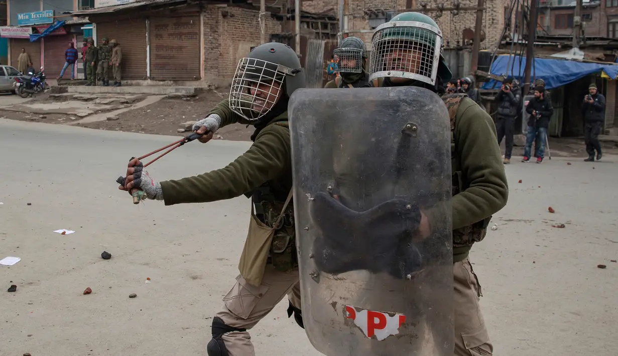 Petugas membubarkan demonstran dengan ketapel di Srinagar, Kashmir, India, Jumat (3/2). Demonstran memprotes hukuman mati yang diberikan oleh pengadilan Kolkata terhadap seorang pria Kashmir bernama Muzaffar Ahmed. (AP Photo / Dar Yasin)