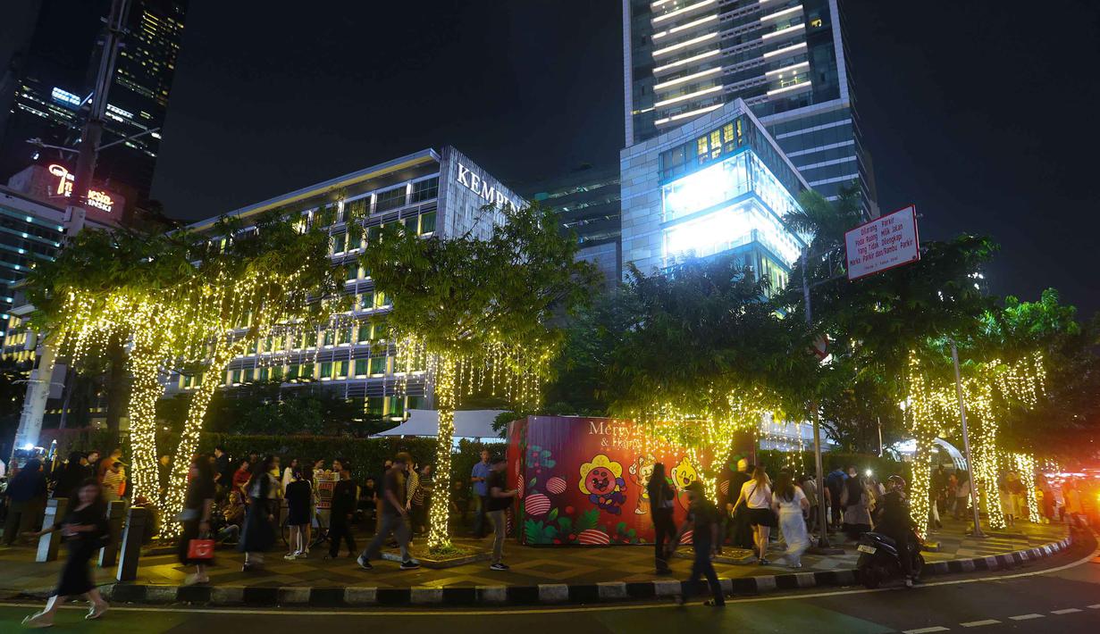 Gelaran ini juga akan menghadirkan pengalaman visual bagi warga yang melintas maupun sengaja datang untuk menikmati suasana malam Jakarta. Tampak dalam foto, warga menikmati suasana Jakarta Light Festival 2025 di sekitar Bundara Hotel Indonesia, Jakarta, Selasa (23/12/2025). (Kapanlagi.com/Budy Santoso)