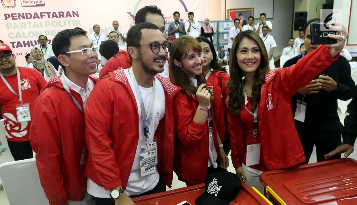 Giring 'Nidji' bersama sejumlah pengurus Partai Solidaritas Indonesia berswafoto ketika mendaftarkan PSI sebagai peserta pemilu 2019 ke KPU, Jakarta, Selasa (10/10). Para pengurus PSI membawa 150 kontainer berkas persyaratan. (Liputan6.com/Johan Tallo)