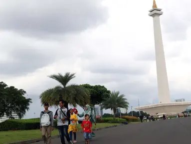 Warga berjalan-jalan di kawasan Monumen Nasional, Jakarta, Jumat (19/4). Libur panjang perayaan Paskah 2019 dimanfaatkan warga untuk berwisata di kawasan Monumen Nasional. (Liputan6.com/Helmi Fithriansyah)