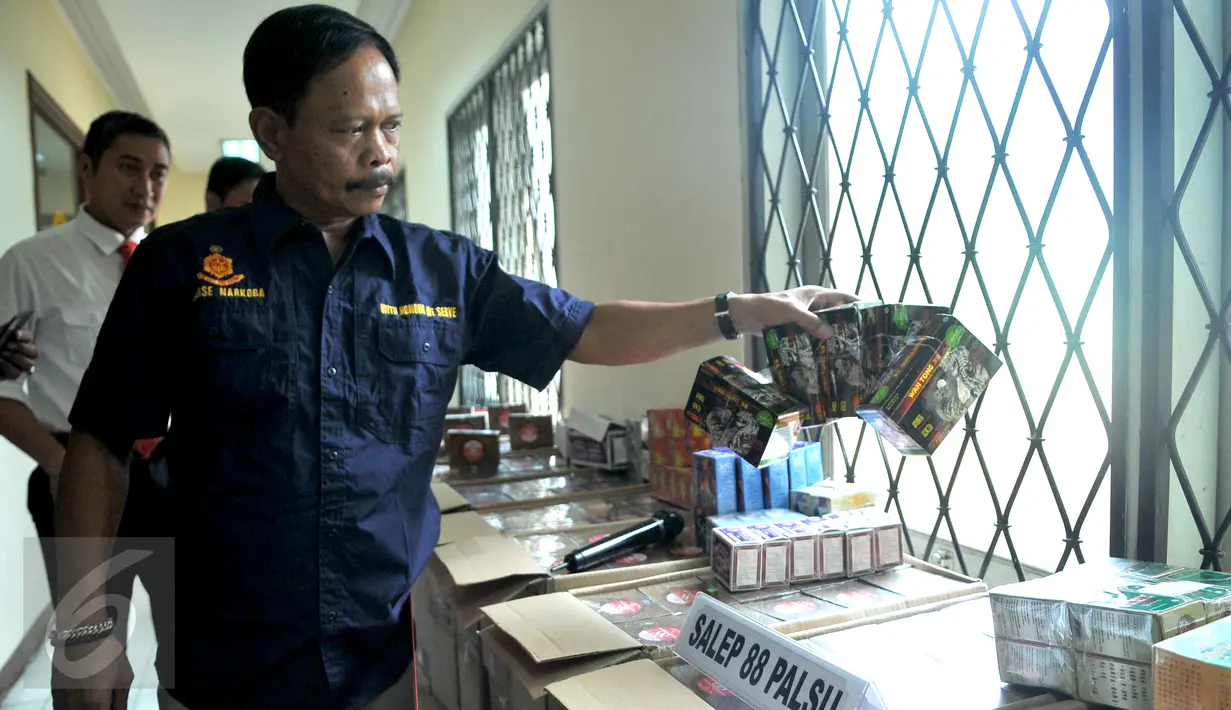 Petugas menunjukan sejumlah barang bukti yang berhasil disita dari penggerebekan rumah yang dijadikan pabrik obat palsu di Bogor saat rilis kasus di Mabes Polri, Jakarta, Jumat (6/11). (Liputan6.com/Gempur M Surya)