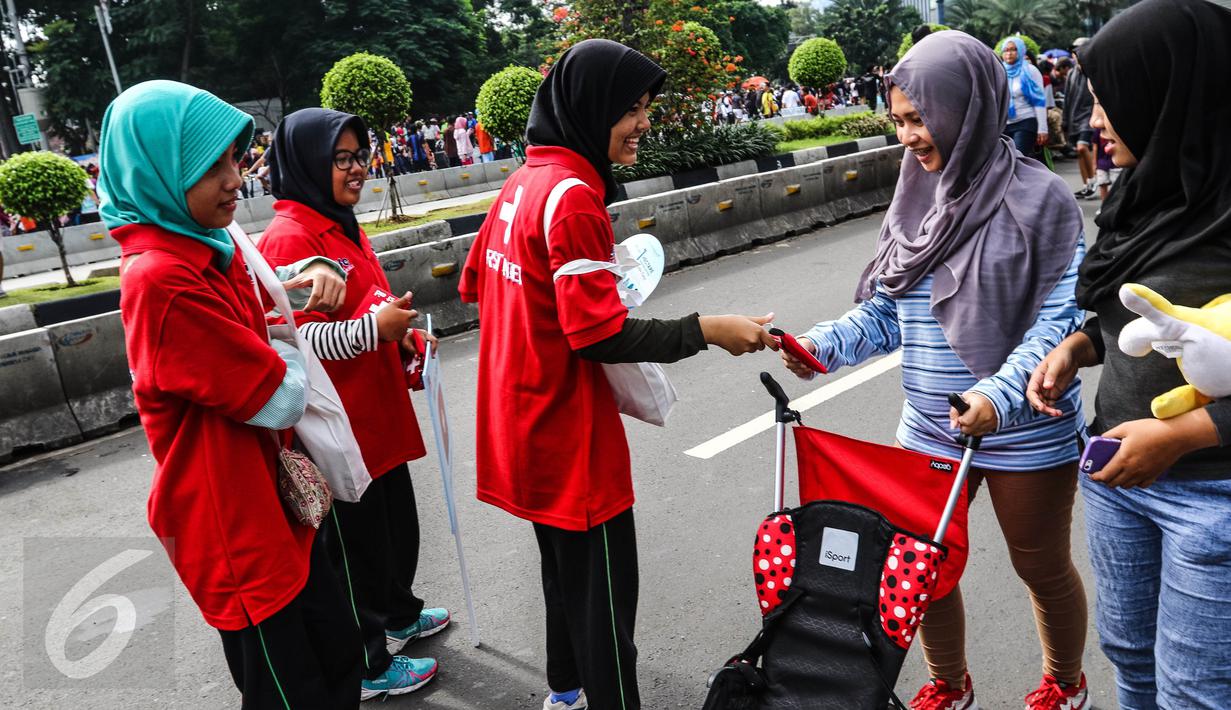Relawan membagikan mini kit P3K kepada pengguna CFD di Jalan MH Thamrin, Jakarta, Minggu (25/0). Hari P3K Sedunia diperingati setiap Sabtu kedua bulan September. (Liputan6.com/Fery Pradolo)