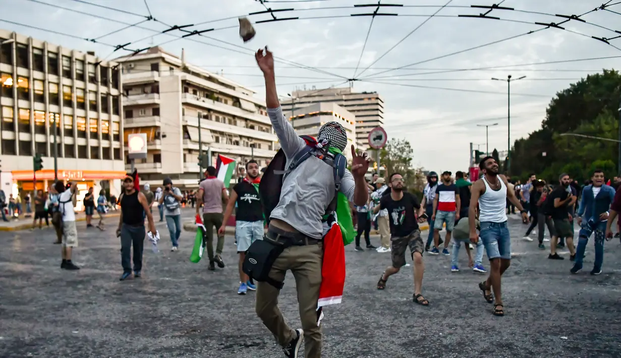 Pengunjuk rasa melempar batu ke kedutaan Israel pada unjuk rasa di Athena, Yunani, Selasa (15/5). Mereka mengecam tentara Israel menembak mati puluhan warga Palestina di perbatasan Gaza yang berunjuk rasa menentang pembukaan kedubes AS (AFP/Aris MESSINIS)