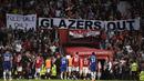 Spanduk bertuliskan "Glazer Out" terpampang di salah satu sisi stadion Old Trafford dalam laga tunda pekan ke-32 Liga Inggris 2022/2023 antara MU melawan Chelsea, Jumat (26/5/2023). (AFP/Oli Scarff)