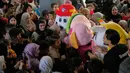 Israel mengklaim serangan tersebut menargetkan infrastruktur dan fasilitas milik Hizbullah guna mencegah serangan roket ke wilayah mereka. Tampak dalam foto, anak-anak berkumpul di sekitar orang-orang yang mengenakan kostum selama acara di mana para sukarelawan menyiapkan bingkisan makanan dan manisan Idulfitri untuk keluarga pengungsi yang merayakan hari raya jauh dari rumah mereka, di sebuah universitas negeri yang diubah menjadi tempat penampungan setelah serangan udara Israel di Beirut, Lebanon, Jumat, 20 Maret 2026. (Foto AP/Hassan Ammar)