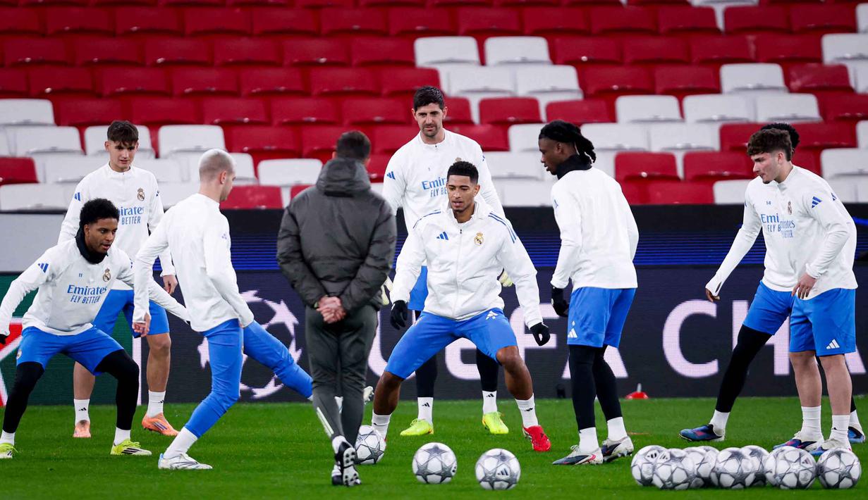 Alvaro Arbeloa menegaskan keengganannya melewati babak playoff karena akan membuat jadwal Real Madrid kian padat. Tampak dalam foto, gelandang Real Madrid asal Inggris, Jude Bellingham (tengah) dan rekan-rekan setimnya berlatih jelang matchweek kedelapan Liga Champions 2025-2026 melawan SL Benfica di stadion Luz, Lisbon pada Selasa 27 Januari 2026. (FILIPE AMORIM/AFP)