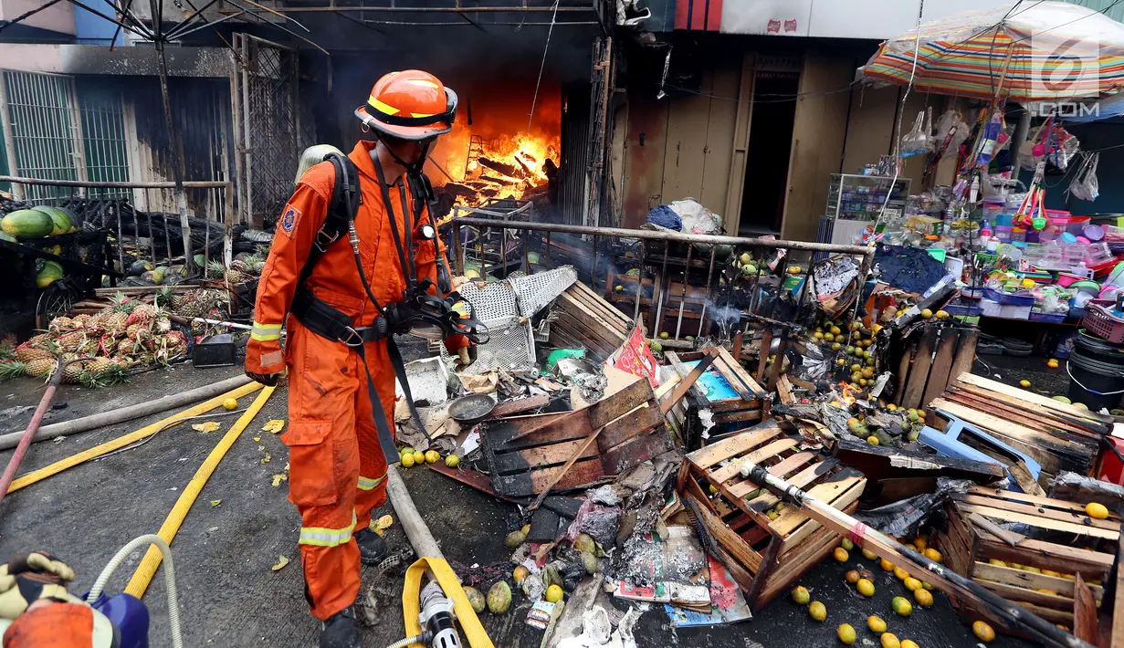 Petugas pemadam kebakaran mengamati api yang melahap ruko di Pasar Kebayoran Lama, Jakarta, Selasa (13/6). Tidak ada korban jiwa dalam kebakaran tersebut. (Liputan6.com/Johan Tallo)