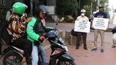 Aktivis Koalisi Pejalan Kaki (KPK) menghadang pengendara sepeda motor yang menerobos trotoar di depan Tempat Pemakaman Umum (TPU) Menteng Pulo, Jalan Casablanca, Jakarta Selatan, Jumat (21/7). (Liputan6.com/ Immanuel Antonius)