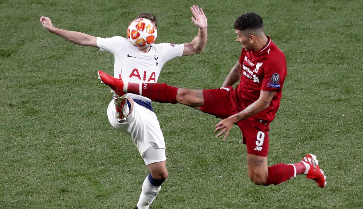Penyerang Liverpool, Roberto Firmino, berebut bola dengan pemain Tottenham Hotspur, Harry Winks, pada laga Liga Champions 2019 di Stadion Wanda Metropolitano, Madrid, Minggu (2/6). Liverpool menang 2-0 atas Tottenham Hotspur. (AP/Armando Franca)