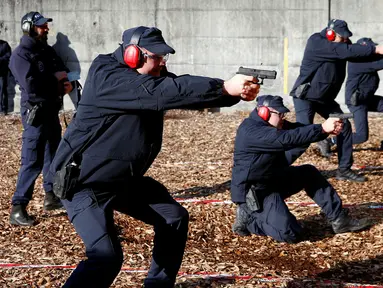 Para anggota Pontifical Swiss Guard saat menjalani latihan tembak di pangkalan militer di Isone, Swiss, (15/11). Pontifical Swiss Guard merupakan satuan keamanan Swiss yang bertugas melakukan pengawalan Paus di Vatikan. (REUTERS/Arnd Wiegmann)